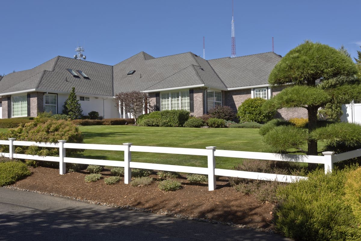 Large home with white fences and manicured lawn Oregon.
